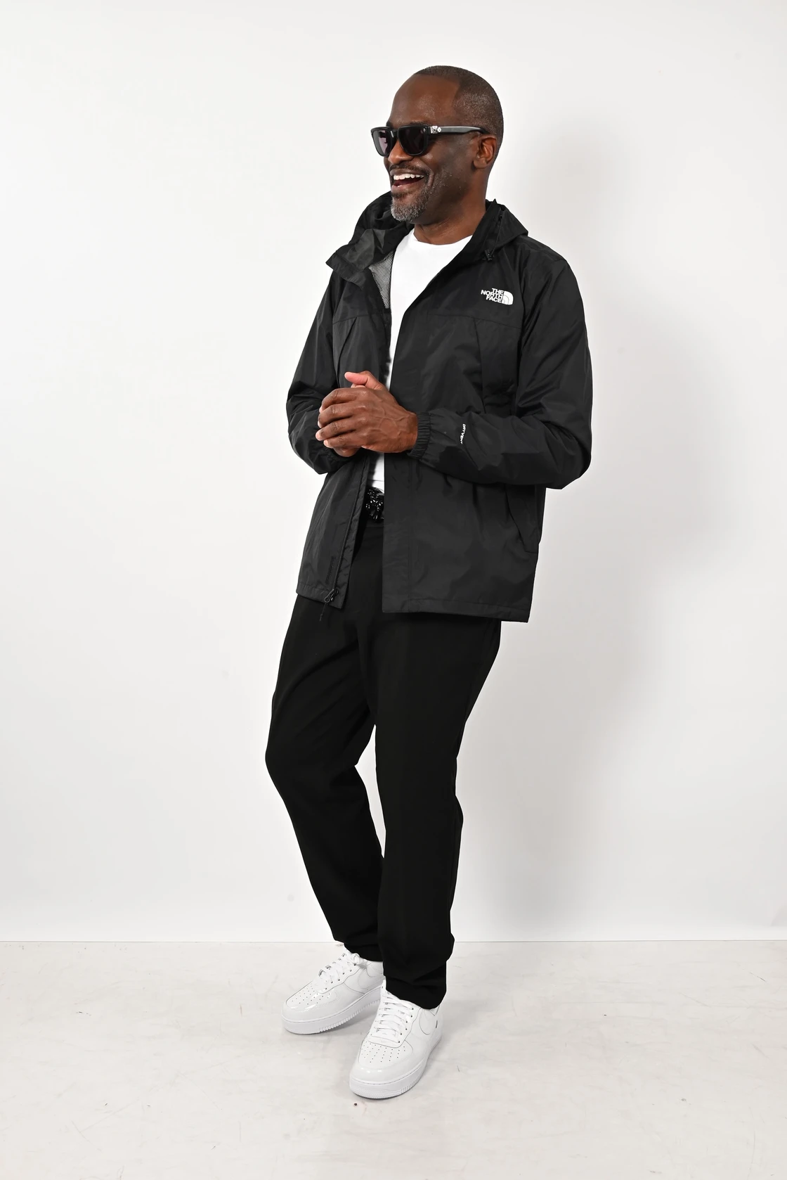 Dr. Glenn Toby smiling in a black jacket and white sneakers